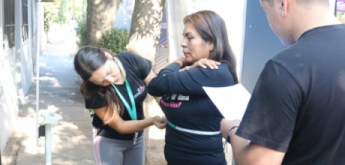Estudiantes y profesora de terapia en actividad física midiendo a mujer para sacar su IMC